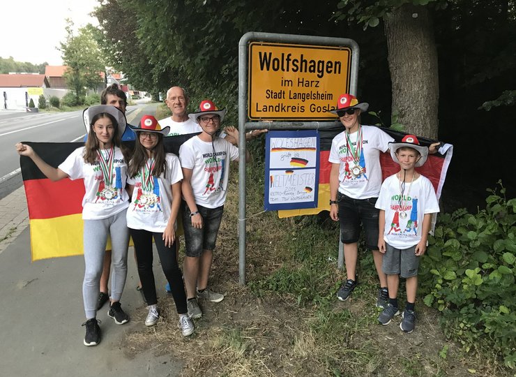 Mitglieder des TSV Eintracht Wolfshagen aus dem Landkreis Goslar vor dem Wolfshagener Straßenschild..