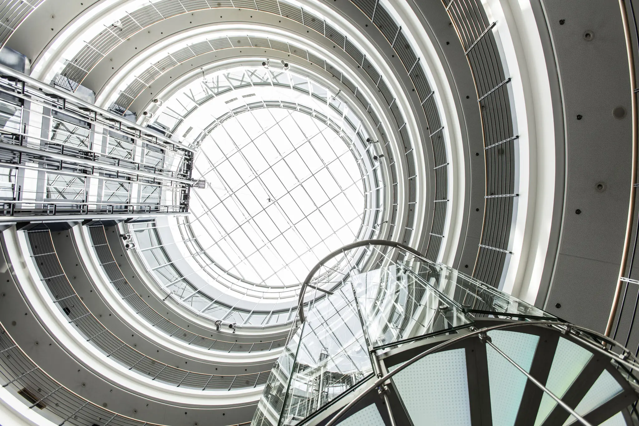 Ein verglastes rundes Gebäude, von unten nach oben fotografiert. 
