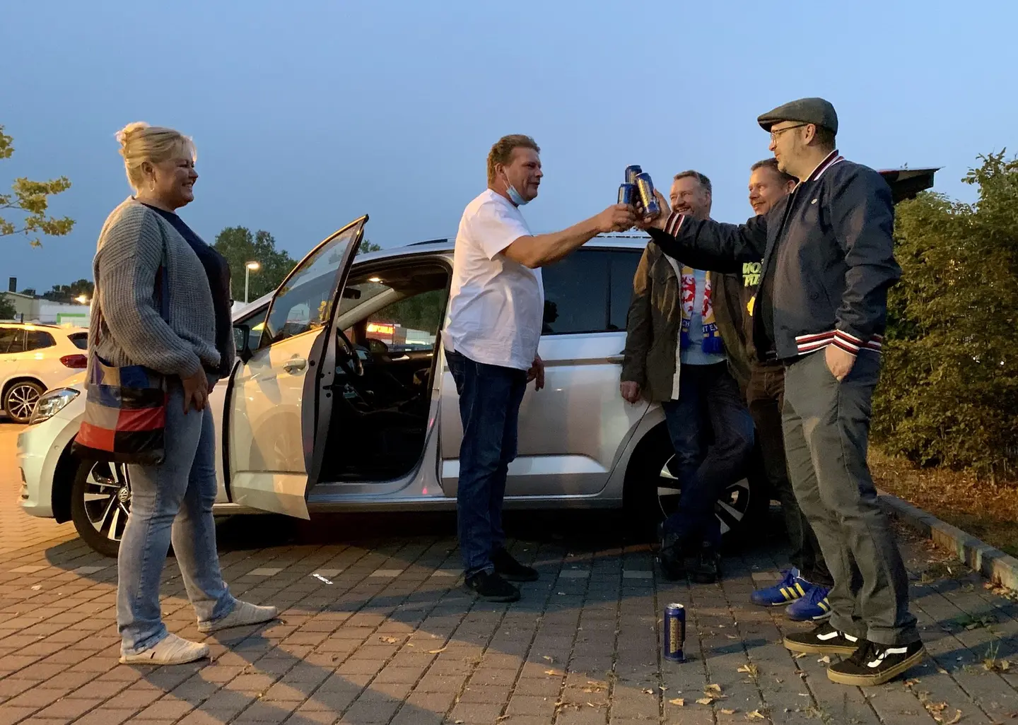 Fünf Eintracht-Fans begrüßen sich und stoßen mit Bierdosen an.