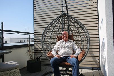 Ein Mann sitzt in einem Hängestuhl.