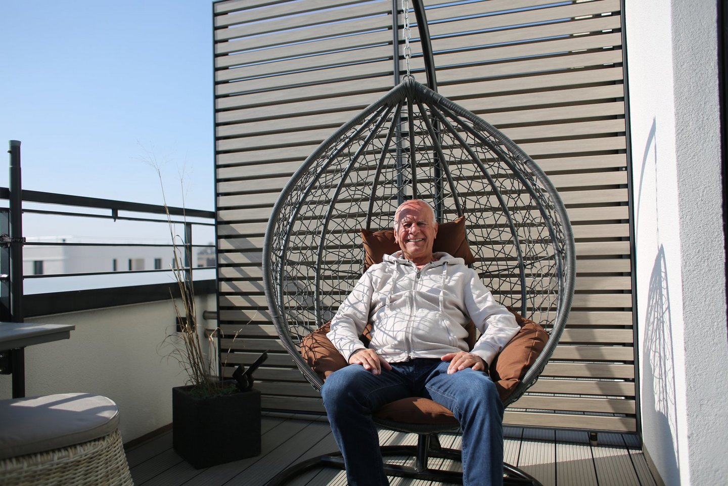 Ein Mann sitzt in einem Hängestuhl.