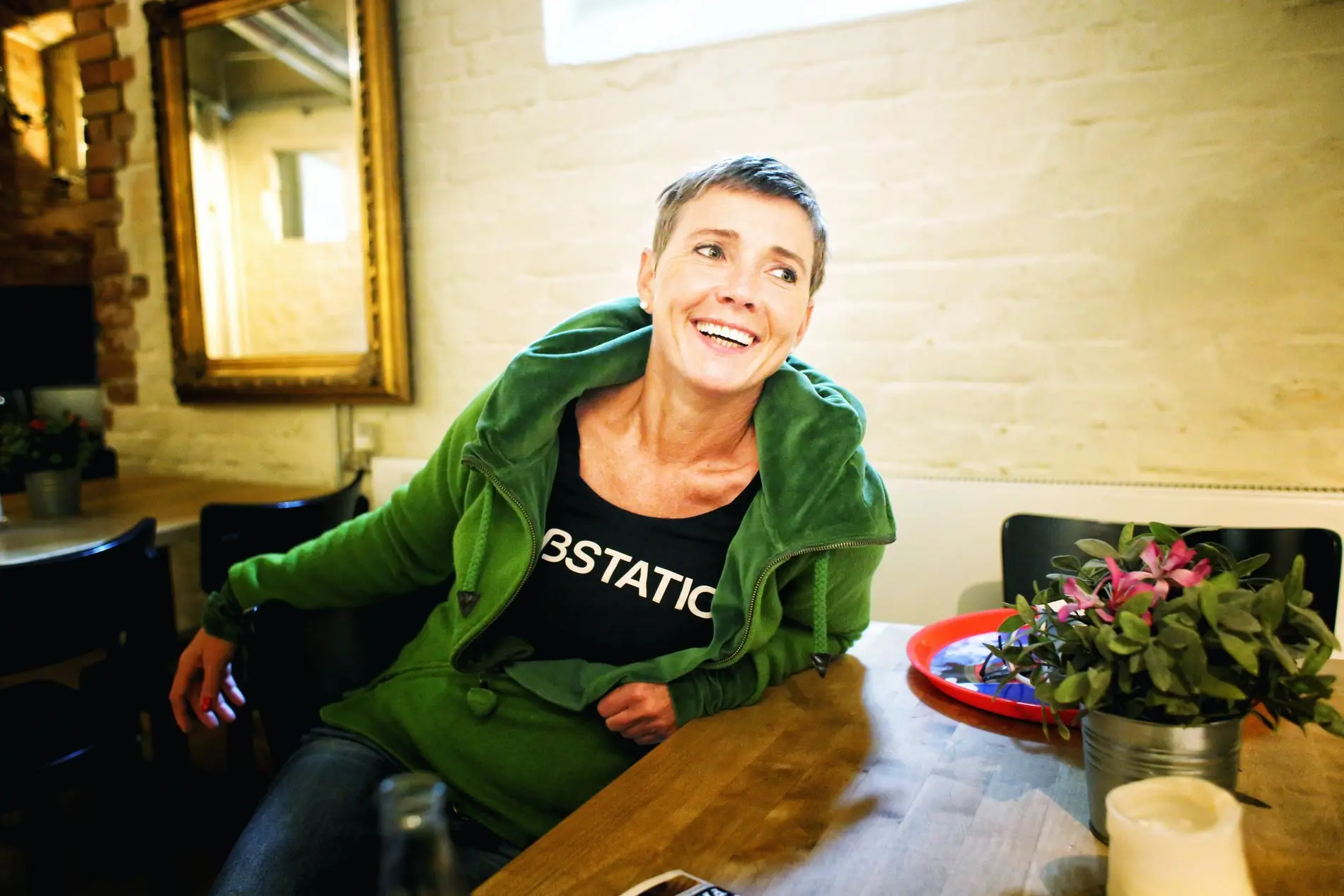 Eine Frau mit kurzen blonden Haaren sitzt in einem Sessel.