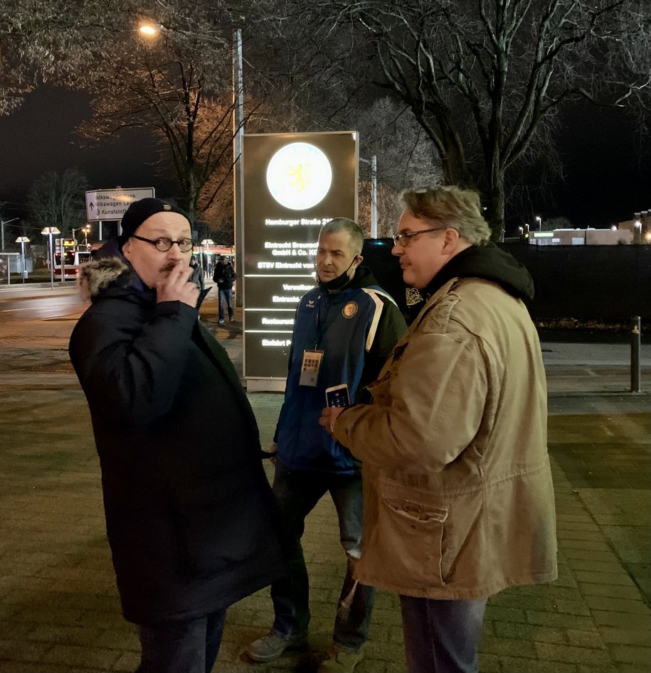 Drei Männer stehen am Stadion-Vorplatz in Braunschweig.