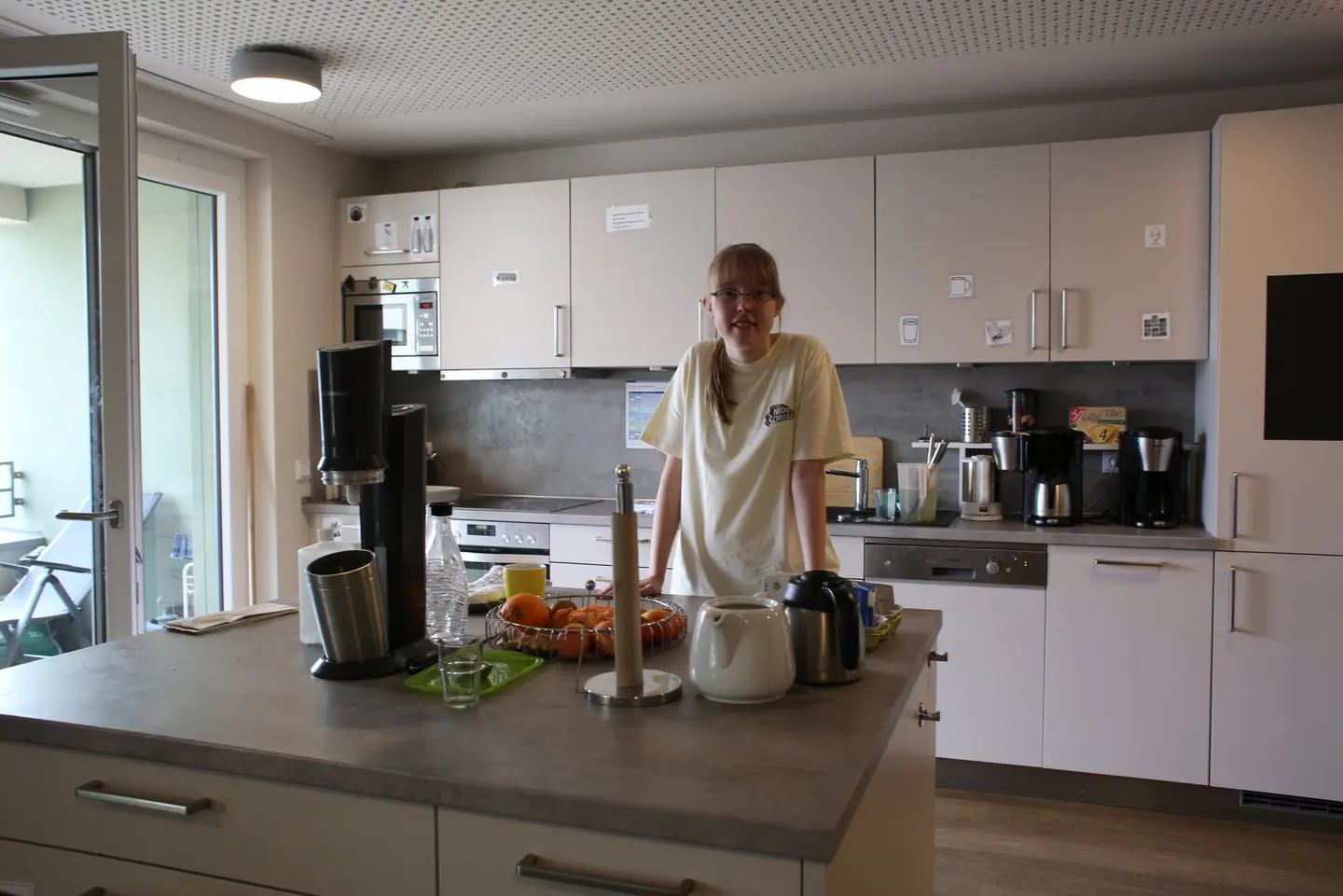 Eine Frau steht an einer Arbeitsfläche in einer Küche.