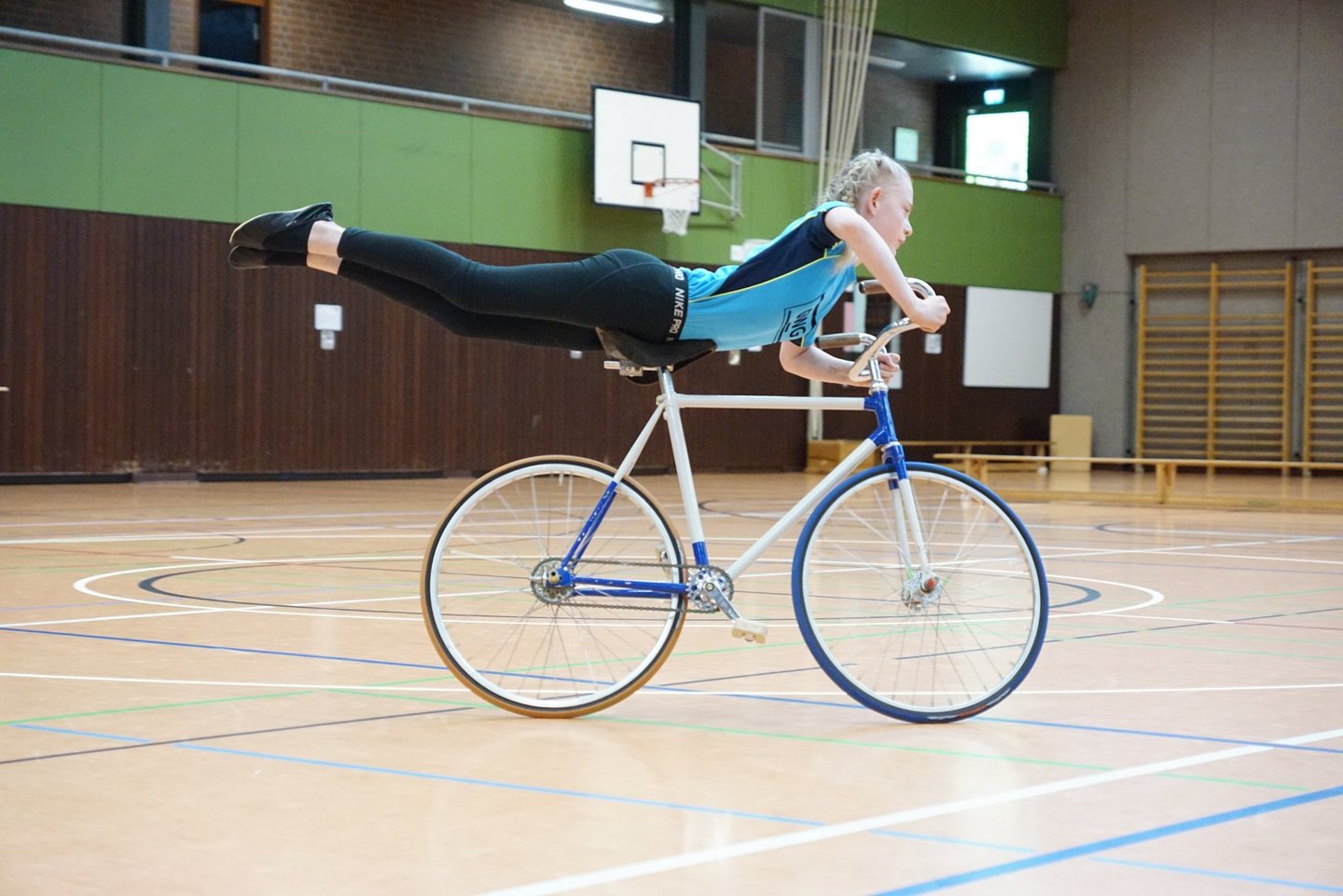 Ein Mädchen beim Kunststück auf dem Fahrrad.
