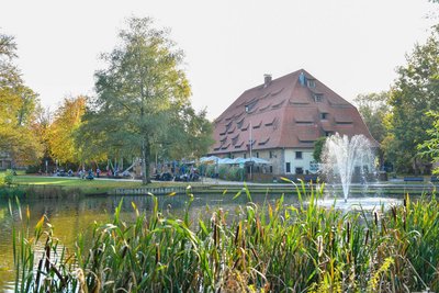 Man blickt über einen Teich samt Springbrunnen auf das Alte Brauhaus zu Fallersleben