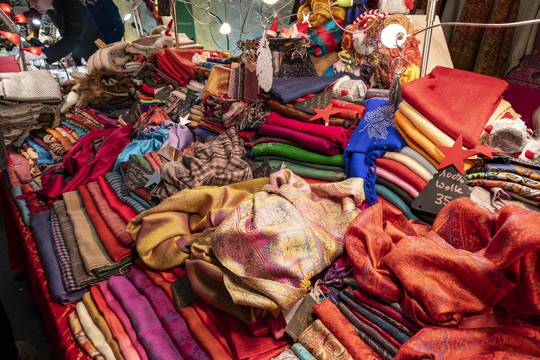 Man sieht warme Schals aneinem Verkaufsstand.