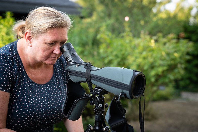 Eine Frau schaut durch ein Fernglas.