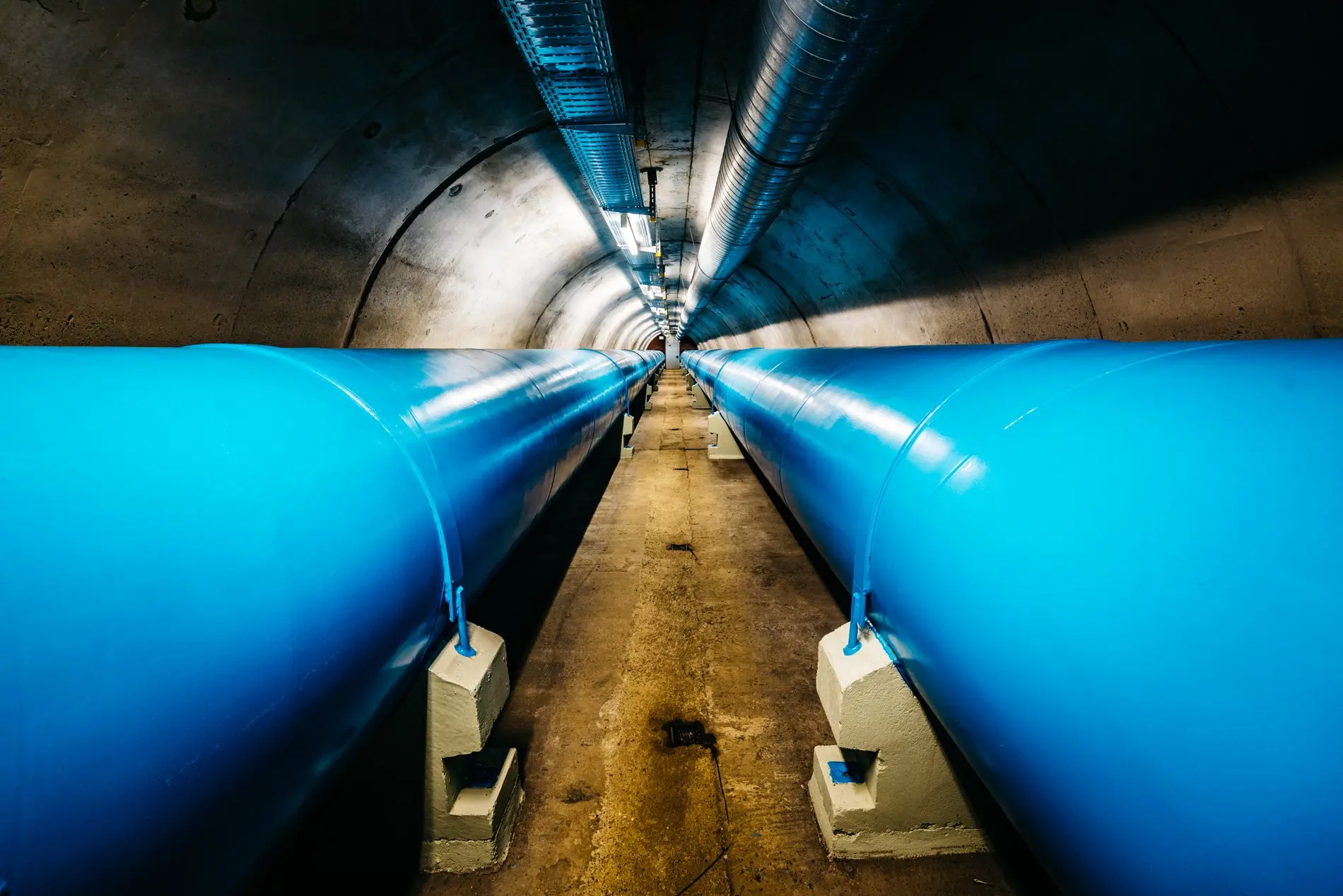 Zwei blaue Röhren verlaufen in einem Tunnel.