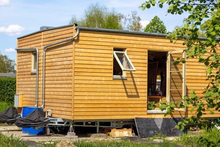Ein Tiney-House. Seine Wände sind aus Holz.