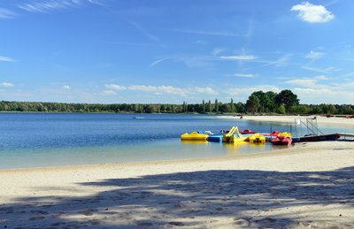 Man blickt auf Tretboote am Strand des Tankumsees