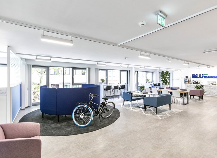 Ein offener, großer Arbeitsraum, an einem Tisch lehnt ein Fahrrad. 