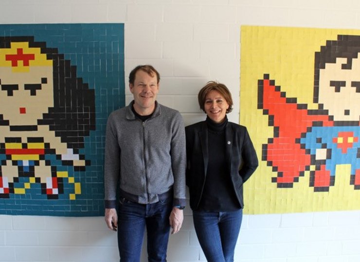 Ein Ehepaar steht zwischen zwei Pop-Art-Bildern. 