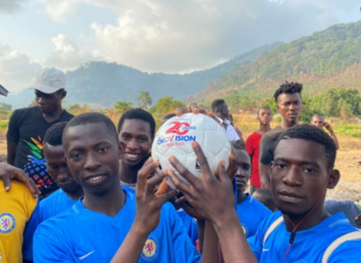 Zwei Fußballer aus Sierra Leone halten zusammen einen Ball.