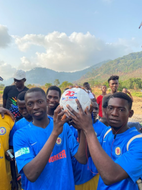 Zwei Fußballer aus Sierra Leone halten zusammen einen Ball.