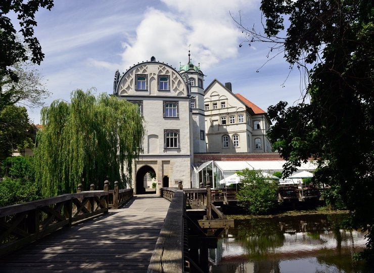 Ein idyllisches weißes Schloss an einem Fluss.