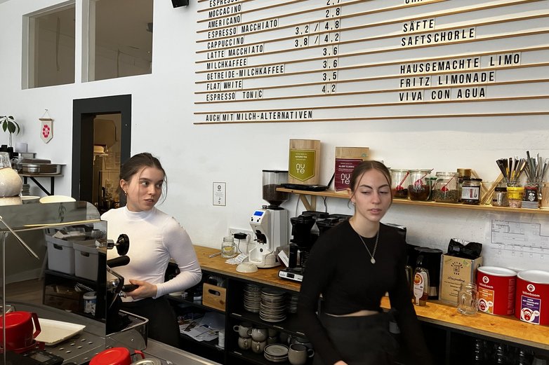 Zwei junge Frauen hinter der Theke eines Cafés.