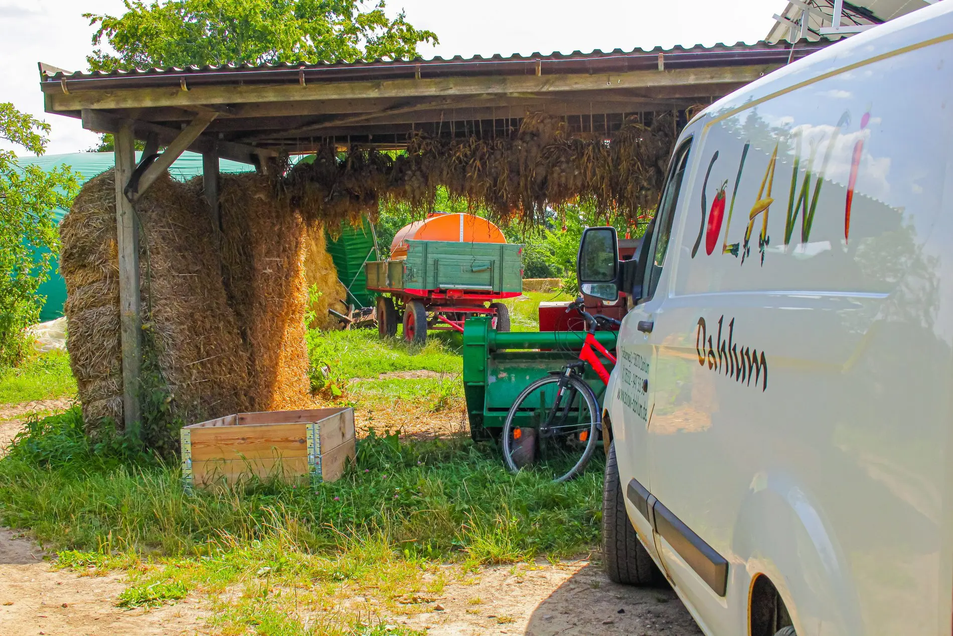 Ein Transporter mit SoLaWi Aufschrift steht auf dem Hof.