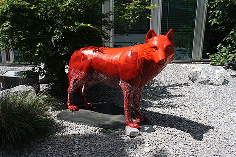 Eine Wolfsstatue in Rot. 