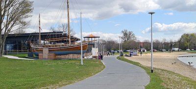 Man blickt auf Gehwege und ein Restaurant samt Segelschiff-Café am Salzgittersee
