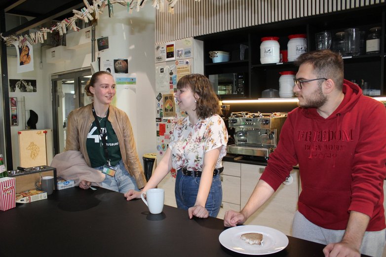 Drei junge Menschen in einer Küche an der Küchentheke.