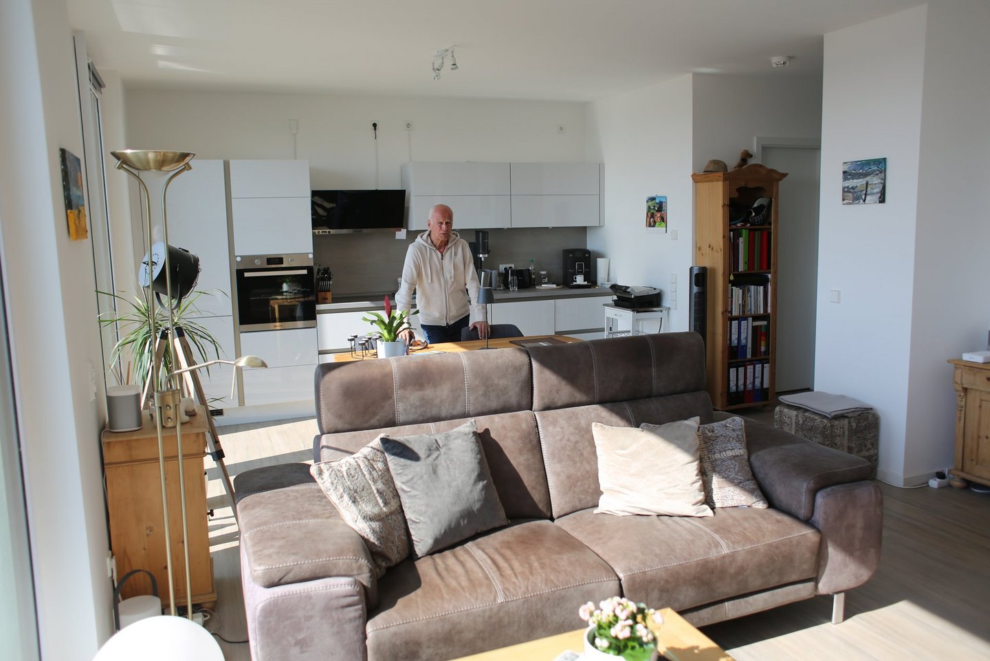 Ein Mann steht in der Mitte seiner Wohnung.