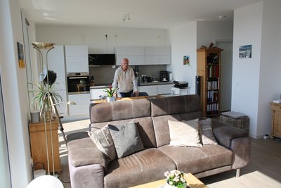 Ein Mann steht in der Mitte seiner Wohnung.