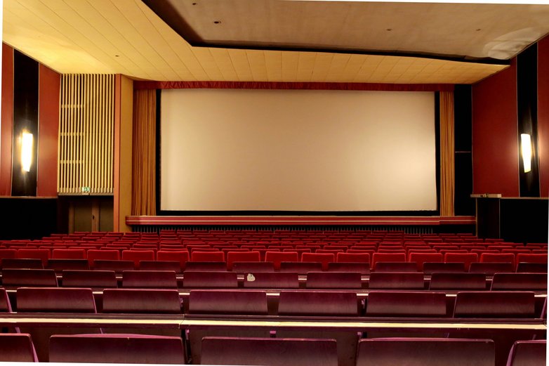 Blick auf Sitze und die Leinwand eines Kinosaals im Astoria Theater in Peine.