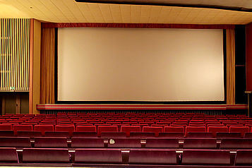 Blick auf Sitze und die Leinwand eines Kinosaals im Astoria Theater in Peine.