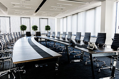 Schwarze Stühle an einem langen Tisch in einem Ein Besprechungsraum im Headquarter von Volkswagen Financial Services in Braunschweig.