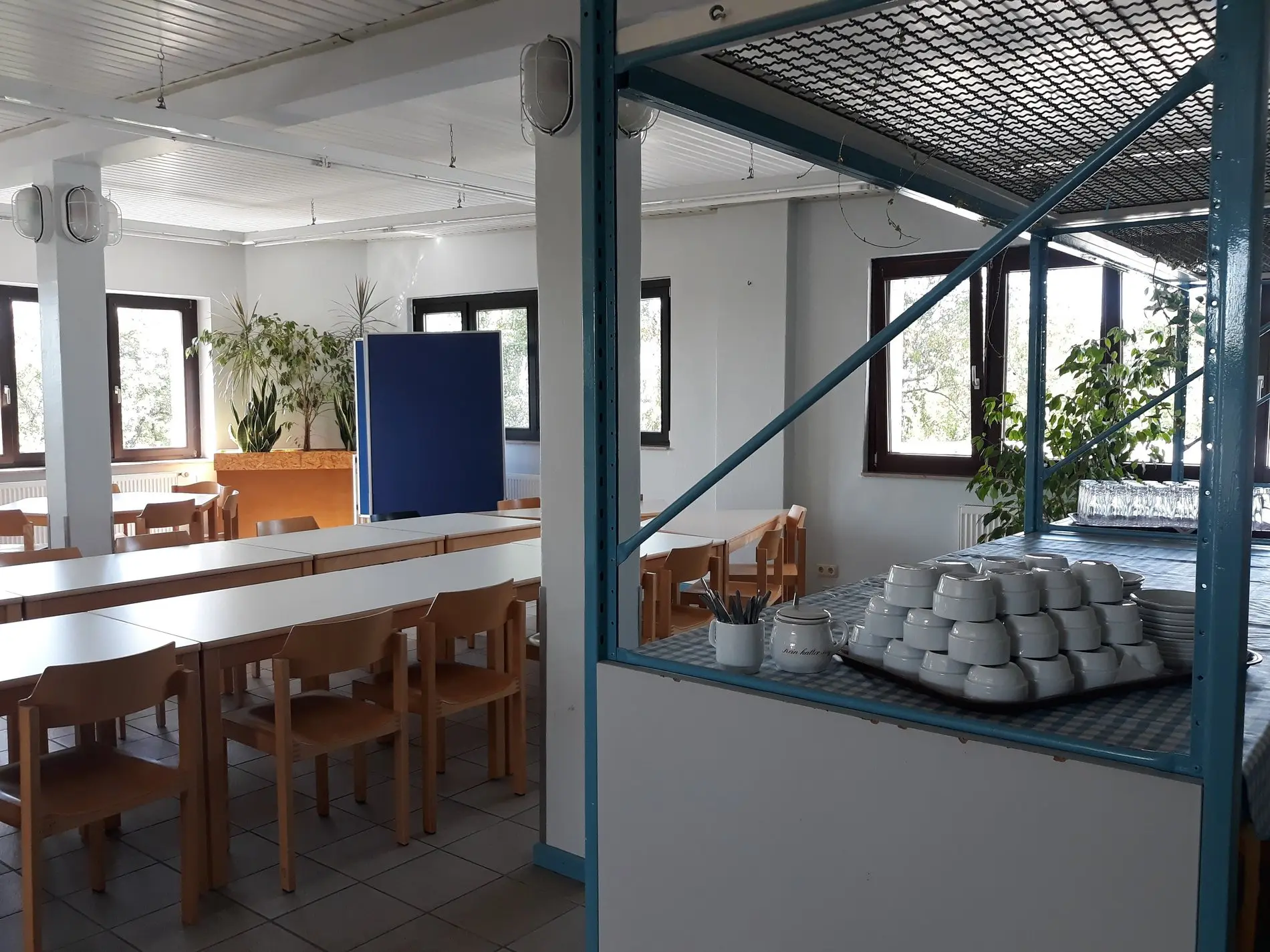 Ein Café mit Holztischen und einer Bar im KJT Salzgitter.