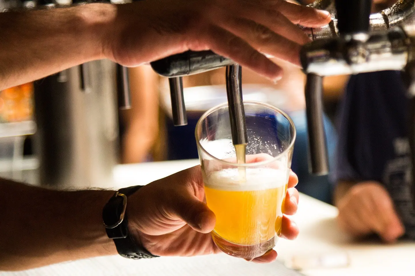 Eine Hand zapft Bier.