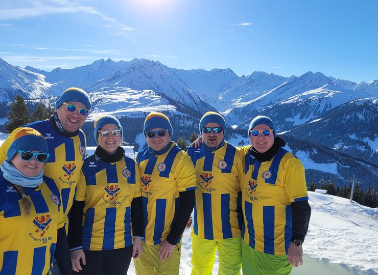 Vier Fans von Eintracht Braunschweig in den verschneiten Bergen. 