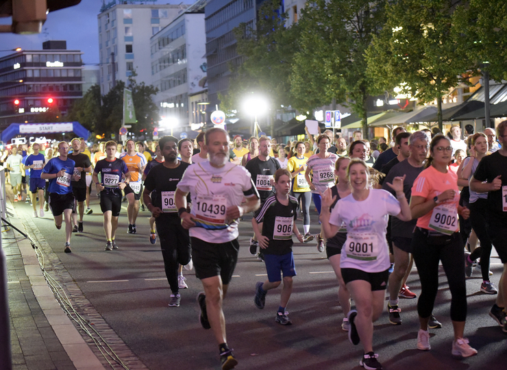 Nachtläufer laufen durch die abendlich beleuchtete Innenstadt.