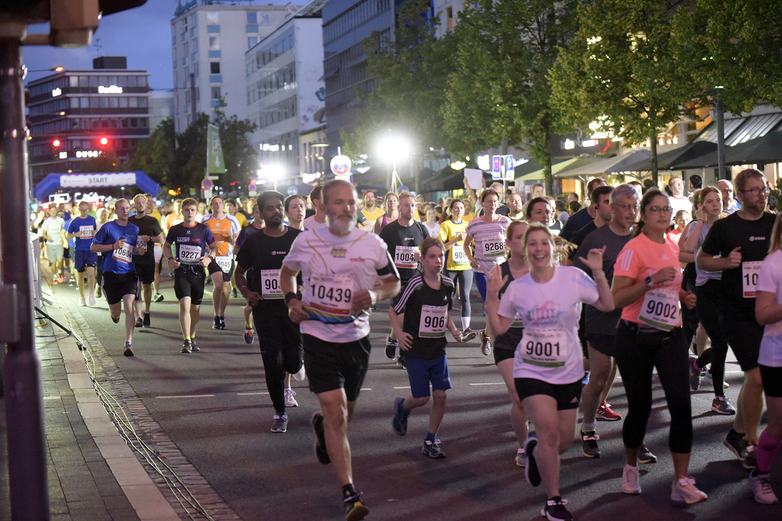 Nachtläufer laufen durch die abendlich beleuchtete Innenstadt.