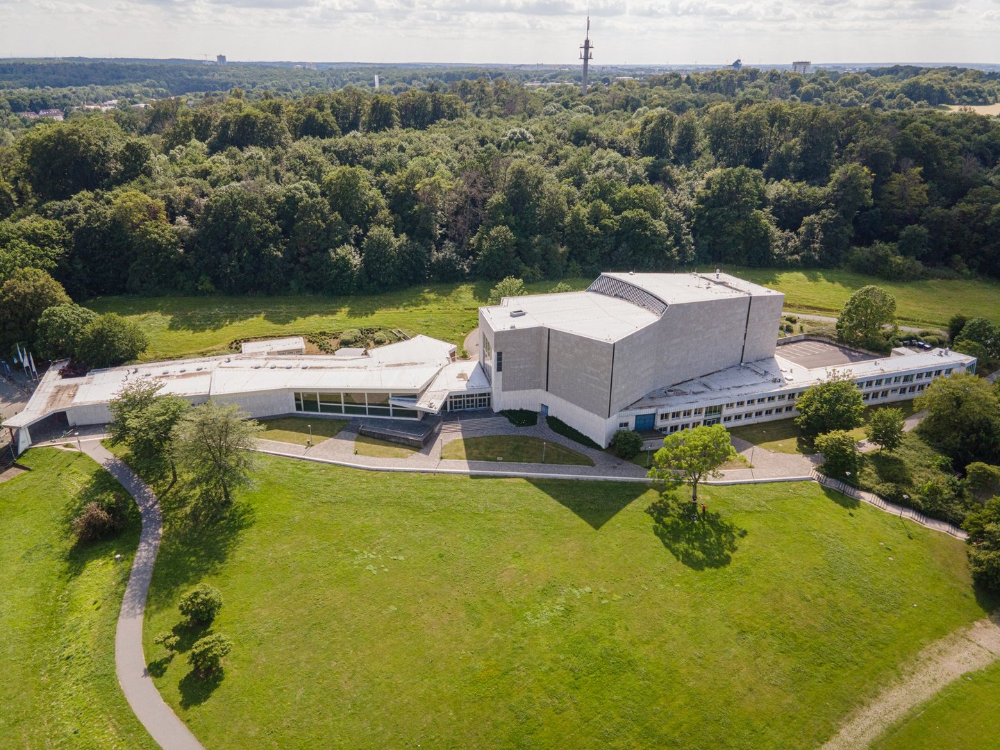 Ein Theater, das nahe eines Waldstücks gelegen ist.