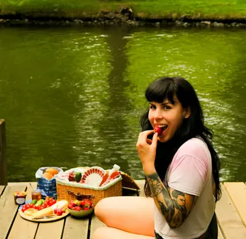 Eine junge Frau frühstückt am Wasser. (Bildrechte: Inga Stang)