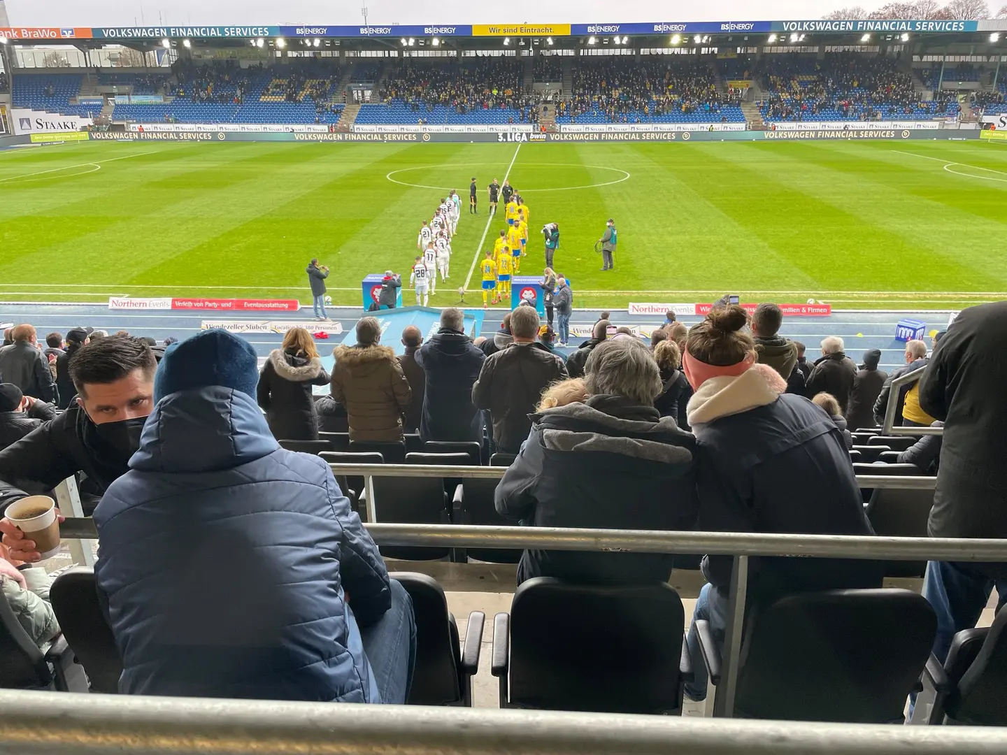 Zwei Fußballmannschaften betreten das Feld.