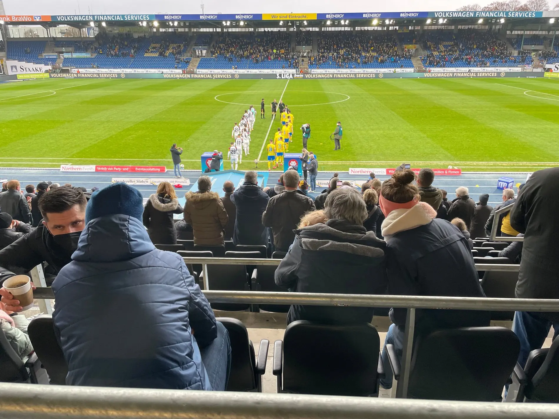 Zwei Fußballmannschaften betreten das Feld.