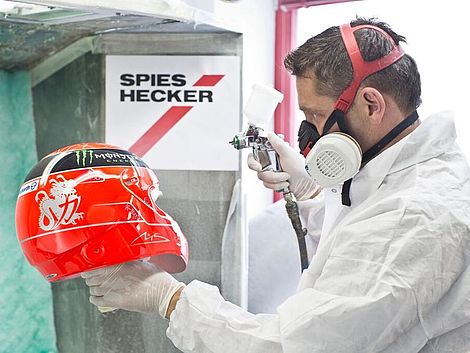 Jens Munser, Inhaber von JMD, färbt einen Helm rot.