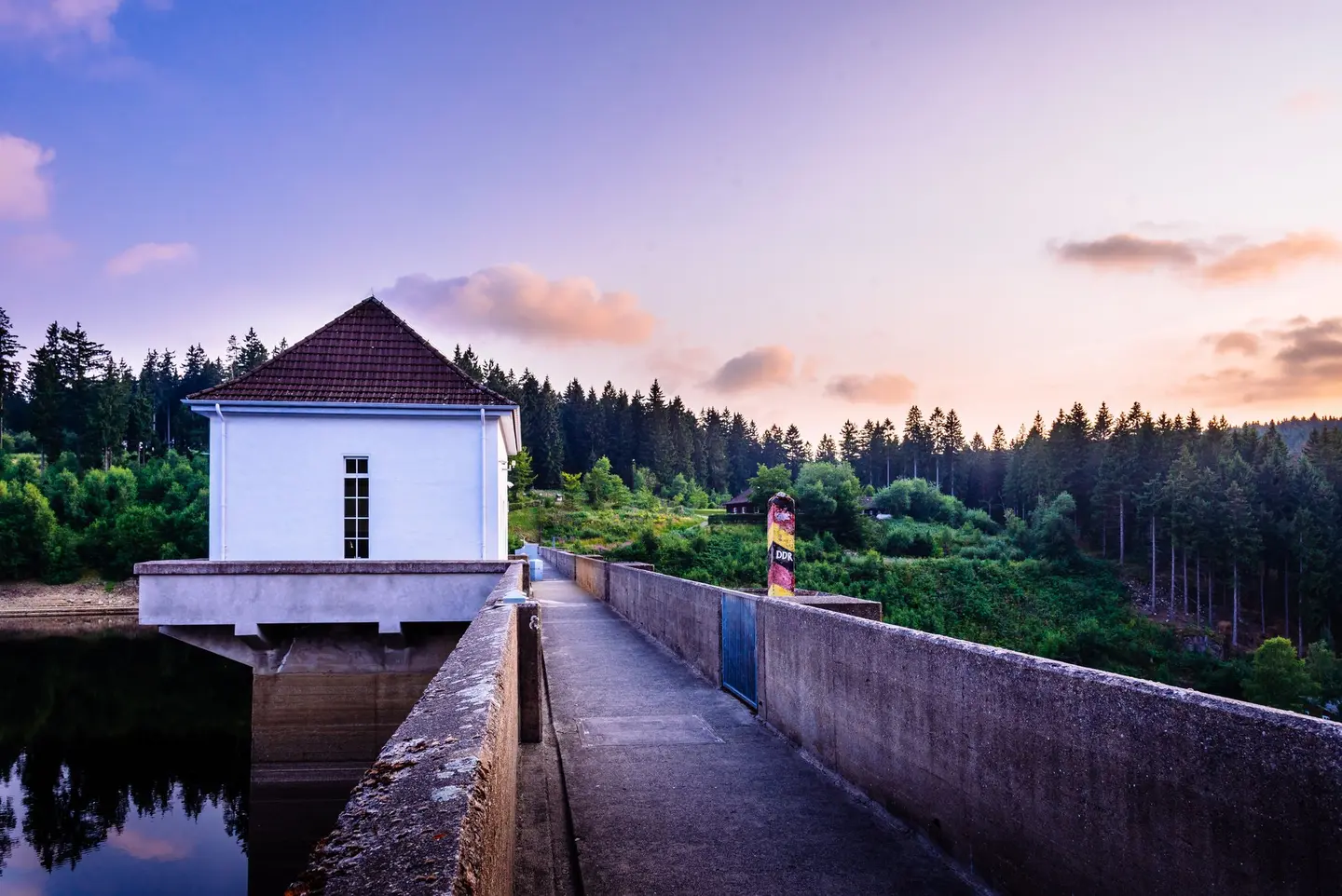 Ein Grenzstein auf einer Staudamm-Mauer.