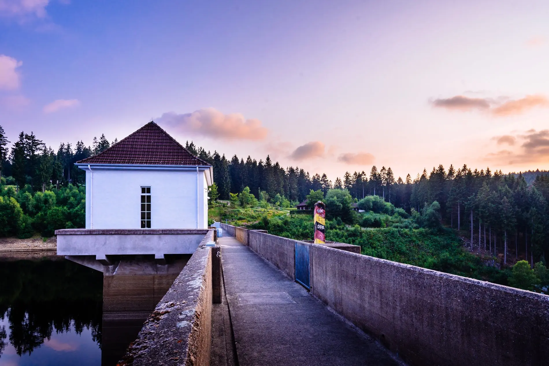 Ein Grenzstein auf einer Staudamm-Mauer.
