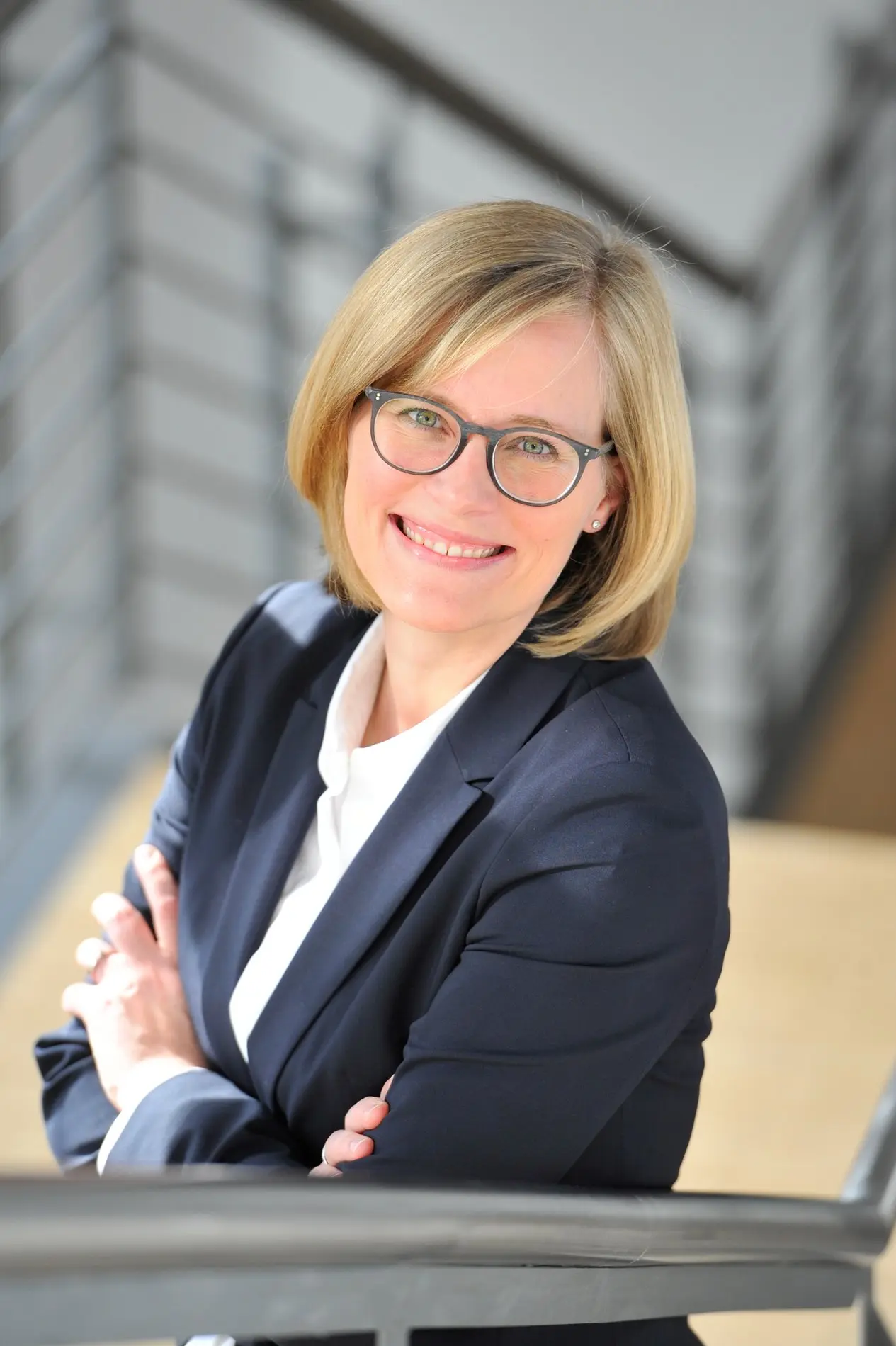 Eine blonde Frau mit Brille.