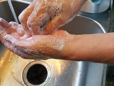 Händewaschen mit Seife über einem Spülbecken.