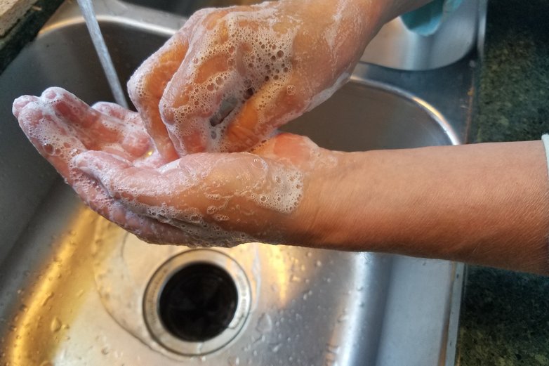 Händewaschen mit Seife über einem Spülbecken.