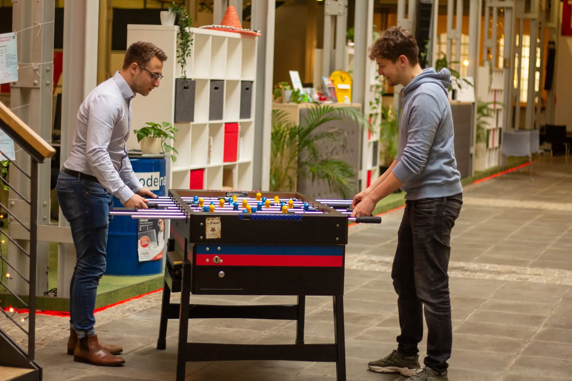 Zwei Männer spielen Tischfußball.