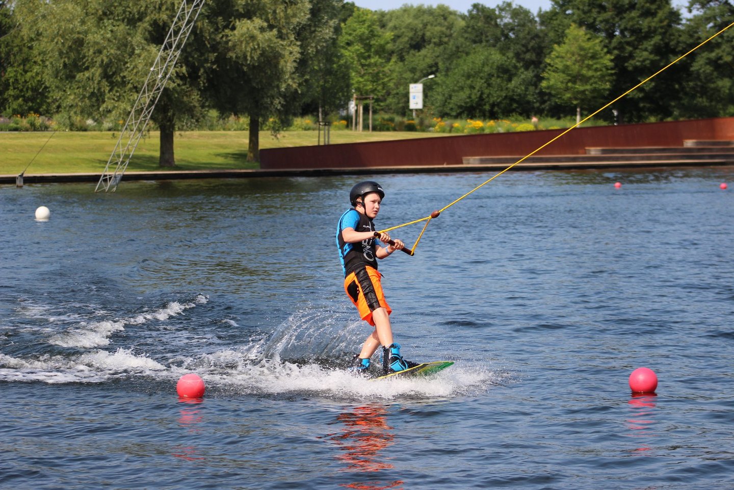 Junge auf einem Wakeboard im Allersee bei Wolfsburg.
