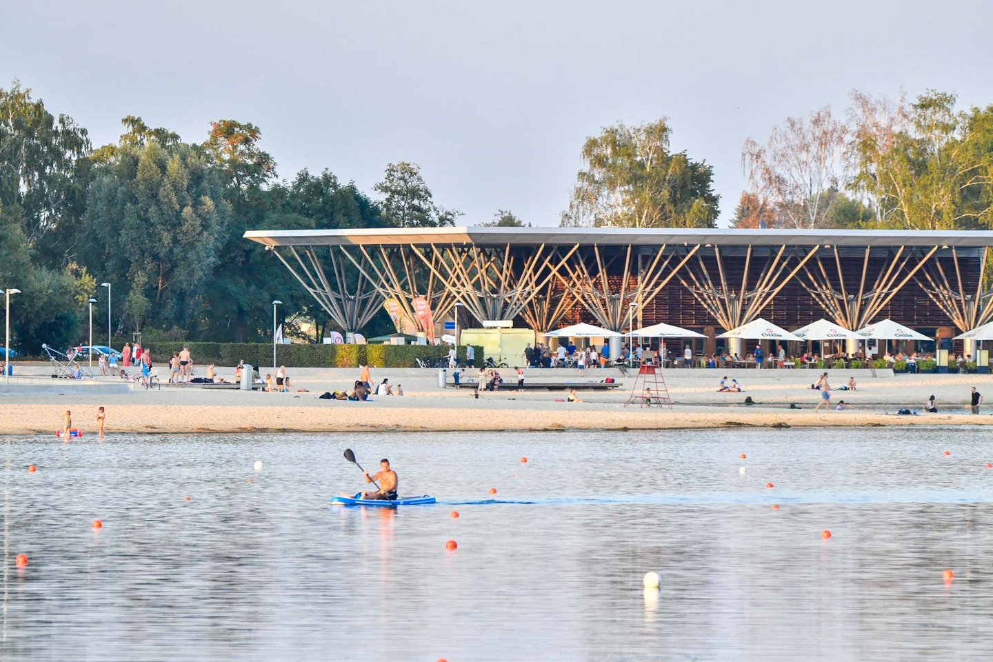 Man blickt auf den Kolumbianischen Pavillon, davor ein Kanufahrer auf dem Allersee