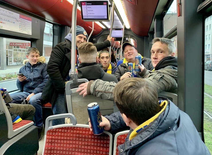 In der Straßenbahn stehen Eintracht-Fans.