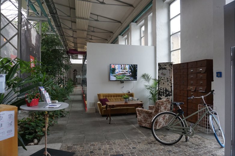 Eine Bürohalle, im Vordergrund eine alte Sitzgruppe und ein Fahrrad.